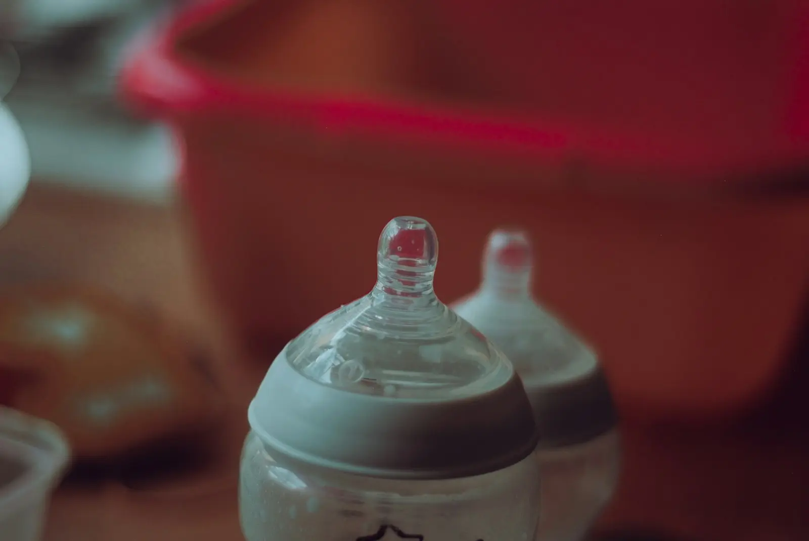 Photo by Jaye Haych clear plastic feeding bottle on red table