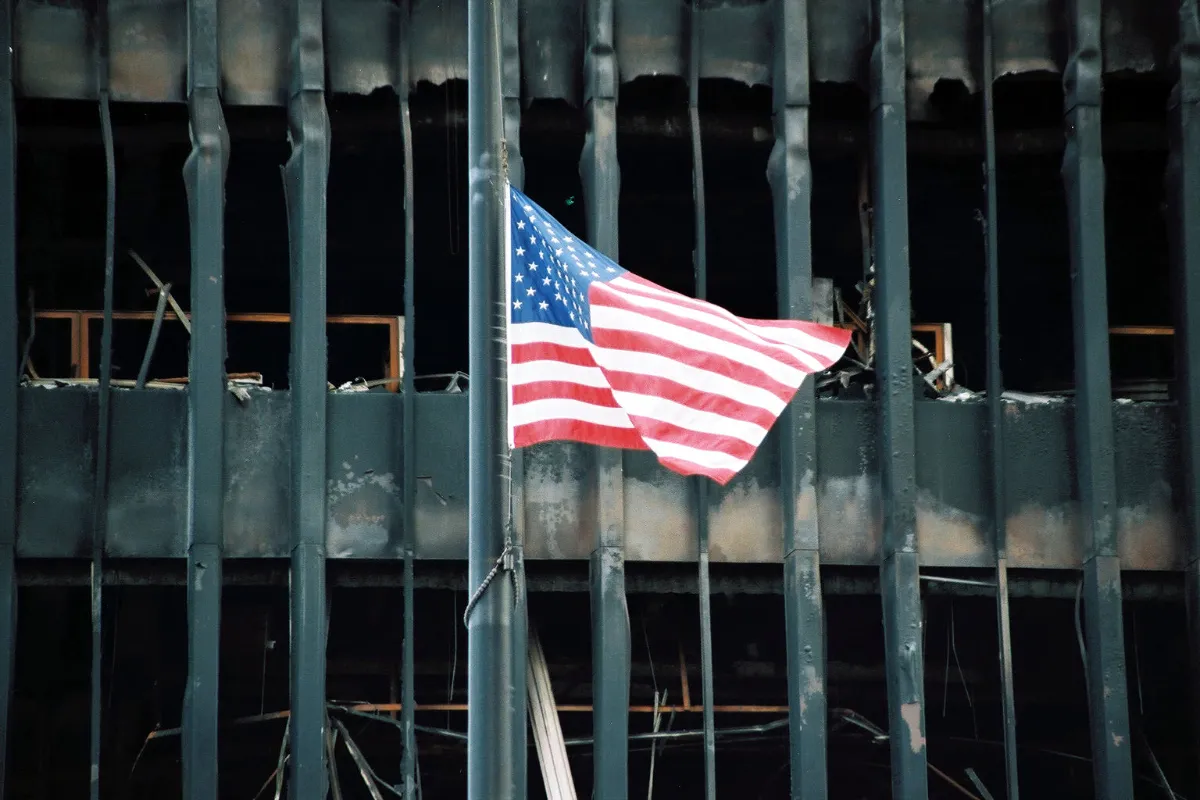 An American flag flies at half-mast above the rubble of the World Trade Center on September 27, 2001