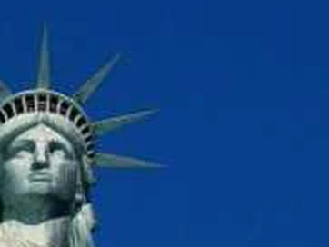 The crown and face of the Statue of Liberty against a blue sky